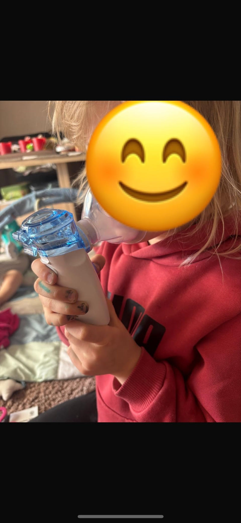 Kind hält das HIMMELSHAUCH Inhalationsgerät; Gesicht im Original mit einem Smiley verdeckt